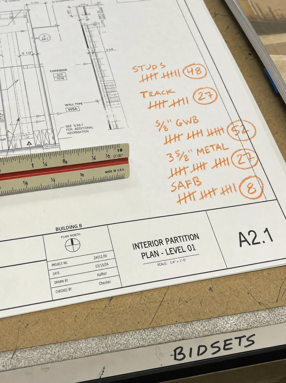 A partition plan sheet marked up with orange grease-pencil count tallies and a scale ruler